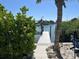 Dock with boat lift on the water with tropical landscaping and a brick walkway at 7912 Causeway S Blvd, St Petersburg, FL 33707