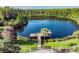 Scenic lake with dock, seating, landscaping and tree-lined border at 8247 Westhaven Dr, Land O Lakes, FL 34638