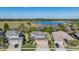Aerial view of a home with a three-car garage and well-manicured lawn situated near a serene lake at 8247 Westhaven Dr, Land O Lakes, FL 34638