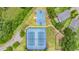 An aerial view showcases community basketball and tennis courts, surrounded by a scenic, wooded area at 8247 Westhaven Dr, Land O Lakes, FL 34638