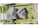 An aerial view of a gray roof on a house surrounded by a green lawn and a white picket fence at 8247 Westhaven Dr, Land O Lakes, FL 34638