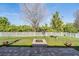 Spacious backyard featuring a brick fire pit, green lawn, and white picket fence at 8247 Westhaven Dr, Land O Lakes, FL 34638