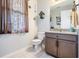 Cozy powder room with floral curtains, decorative birdhouse, vanity and updated fixtures at 8247 Westhaven Dr, Land O Lakes, FL 34638