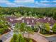 Aerial view of a clubhouse with a circular driveway, lush landscaping, and a pool area surrounded by palm trees at 8247 Westhaven Dr, Land O Lakes, FL 34638