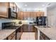 A modern kitchen features granite countertops, wooden cabinets, and modern stainless steel appliances at 8247 Westhaven Dr, Land O Lakes, FL 34638