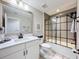 Well-lit bathroom with quartz countertop, black hardware, tile shower with black-trim, and a white rug at 8578 Gibbons Grove Loop, Land O Lakes, FL 34637