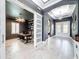Hallway leading to an office with a barn door and a beautiful chandelier in the foyer at 8578 Gibbons Grove Loop, Land O Lakes, FL 34637