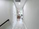 Bright hallway with white wood-look tile leads to the living room and features a closet for storage at 8578 Gibbons Grove Loop, Land O Lakes, FL 34637