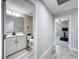 Hallway leads to the guest bathroom and to a bedroom with a ceiling fan and exercise equipment at 8578 Gibbons Grove Loop, Land O Lakes, FL 34637