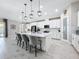 Open kitchen featuring a large island with seating, sleek white cabinetry, and modern light fixtures at 8578 Gibbons Grove Loop, Land O Lakes, FL 34637
