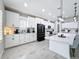 Modern kitchen with white cabinetry, granite countertops, stainless steel appliances, and stylish tile flooring at 8578 Gibbons Grove Loop, Land O Lakes, FL 34637