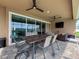 Covered lanai area offers a dining table, seating, and a view of the pool and fenced-in yard at 8578 Gibbons Grove Loop, Land O Lakes, FL 34637
