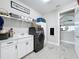 Well-organized laundry room equipped with a front-load washer and dryer, sink, and ample storage space at 8578 Gibbons Grove Loop, Land O Lakes, FL 34637