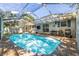 Inviting screened pool area with brick patio, lounge chairs, and lush greenery at 8766 91St St, Seminole, FL 33777