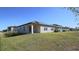A view of the back of the house, with a well-manicured lawn and solar panels at 901 Golden Shiner Ave, Ruskin, FL 33570