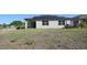 Rear view of home with solar panels and grassy lawn with patio at 901 Golden Shiner Ave, Ruskin, FL 33570