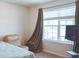 Bright bedroom featuring a large window with blinds and neutral decor at 901 Golden Shiner Ave, Ruskin, FL 33570