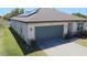 Attractive home exterior featuring a two-car garage, solar panels, well-maintained landscaping, and modern design at 901 Golden Shiner Ave, Ruskin, FL 33570
