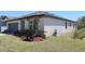 Landscaped front yard with a well-maintained lawn, mature plants, and an irrigation system for easy upkeep at 901 Golden Shiner Ave, Ruskin, FL 33570