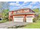 Beautiful two-story home featuring an attached two-car garage, an orange facade, and well-maintained landscaping at 9102 Kentucky Day Ct, Gibsonton, FL 33534