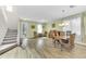 Spacious living room featuring hardwood floors, staircase, antique table and chairs, and plenty of natural light at 9102 Kentucky Day Ct, Gibsonton, FL 33534