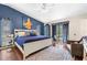 This spacious primary bedroom features stylish blue accent walls, hardwood floors, and a ceiling fan at 9626 Leeward Ave, Largo, FL 33773