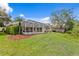 Expansive backyard featuring a pool, screened lanai, lush lawn, and manicured landscaping at 10228 Estuary Dr, Tampa, FL 33647