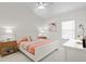 Bright bedroom with ceiling fan features neutral carpet, flamingo wall art and a large window for natural light at 10228 Estuary Dr, Tampa, FL 33647