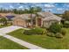 Beautiful home with lush landscaping, a tile roof, and a spacious three-car garage, exuding curb appeal at 10228 Estuary Dr, Tampa, FL 33647