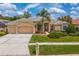 Charming home featuring manicured lawn, tile roof, and three-car garage at 10228 Estuary Dr, Tampa, FL 33647