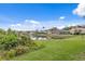 Scenic lake view showcasing lush green landscaping and charming homes in the neighborhood at 10228 Estuary Dr, Tampa, FL 33647