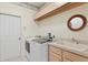 Bright laundry room featuring modern washer and dryer, cabinets for storage, and a utility sink at 10228 Estuary Dr, Tampa, FL 33647