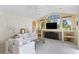 Bright living room with vaulted ceilings, large windows, and comfortable white couches at 10228 Estuary Dr, Tampa, FL 33647