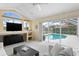 Bright living room with large windows offering a pool view and access to outdoor patio at 10228 Estuary Dr, Tampa, FL 33647