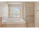 Main bathroom featuring a large soaking tub and glass-enclosed shower at 10228 Estuary Dr, Tampa, FL 33647