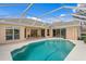 Gorgeous pool area with screened enclosure, integrated steps, and a view of the house at 10228 Estuary Dr, Tampa, FL 33647