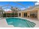 Beautiful pool with covered enclosure, offering privacy and views of the home's exterior at 10228 Estuary Dr, Tampa, FL 33647