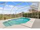 A beautiful screened-in pool offers a serene view of the lake and surrounding neighborhood at 10228 Estuary Dr, Tampa, FL 33647
