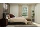 Well-lit bedroom featuring a comfortable bed, neutral tones, and a view to the yard at 11959 Brae Way, Dade City, FL 33525