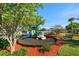 Community playground surrounded by mulch, lush greenery, a comfortable park bench, and a palm tree at 12346 Country White Cir, Tampa, FL 33635