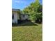 View of the back of the house with grass and shrubbery at 1448 Lemon St, Clearwater, FL 33756