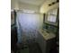 Modest bathroom featuring a floral shower curtain, a white vanity, and green tiled walls at 1448 Lemon St, Clearwater, FL 33756