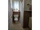 Cozy bathroom with wood paneling, a toilet, and a shower with a curtain at 1448 Lemon St, Clearwater, FL 33756