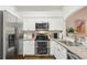 Modern kitchen featuring stainless steel appliances, granite countertops, and white cabinetry at 18187 Paradise Point Dr, Tampa, FL 33647
