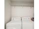Bright laundry area featuring a white washer and dryer, along with a convenient overhead hanging rod at 18187 Paradise Point Dr, Tampa, FL 33647