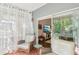 Enclosed sunroom area with tile floors, wicker chairs, curtains and a sliding glass door at 18187 Paradise Point Dr, Tampa, FL 33647