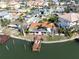 Waterfront property with a dock and outdoor seating, surrounded by lush landscaping and neighborhood views at 187 175Th Terrace E Dr, Redington Shores, FL 33708