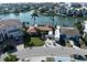 Beautiful aerial view of a waterfront home with tile roof and RV parking, surrounded by lush landscaping and a tranquil canal at 187 175Th Terrace E Dr, Redington Shores, FL 33708