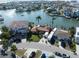 Overhead view of waterfront home with tile roof, RV parking, and a lush landscape on a scenic canal at 187 175Th Terrace E Dr, Redington Shores, FL 33708
