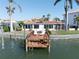 This waterfront property includes a private dock, outdoor seating, and well-manicured landscaping at 187 175Th Terrace E Dr, Redington Shores, FL 33708